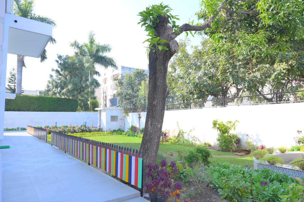 Children playing happily on the preschool playground in front of the school building